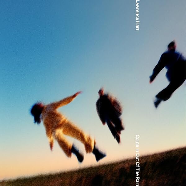 Album cover with three blurred figures appearing to jump against a blue sky.