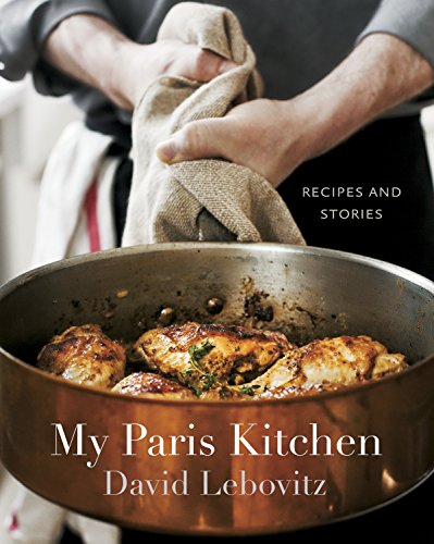 Cookbook cover with roasted chicken in a copper pan and hands holding cloth.