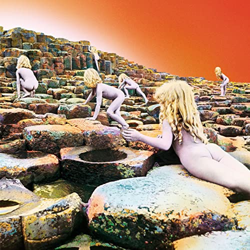 Naked figures climb a rocky, hexagonal landscape under an orange sky.