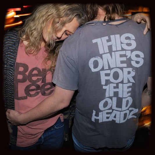 Two people embracing, both wearing t-shirts with text on the back and front.