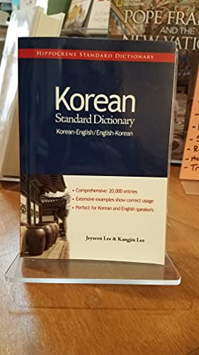 Red Korean-English dictionary displayed on a clear plastic stand.