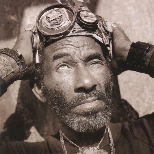 Sepia-toned portrait of a man wearing goggles on his forehead, looking upward.