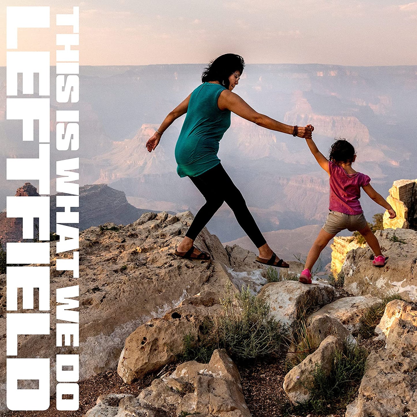 CD cover: Woman and child reaching out on a canyon edge.