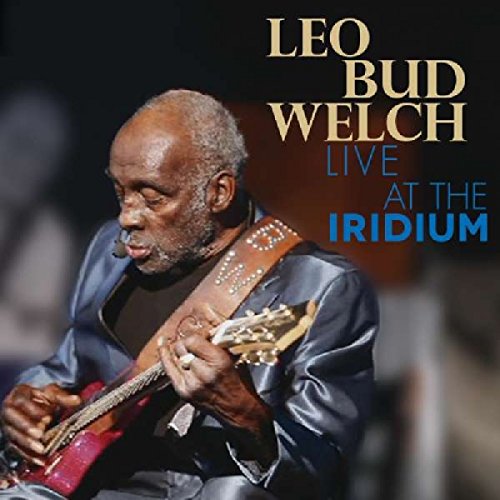 "Album cover featuring a man playing a red electric guitar, with text overlay."