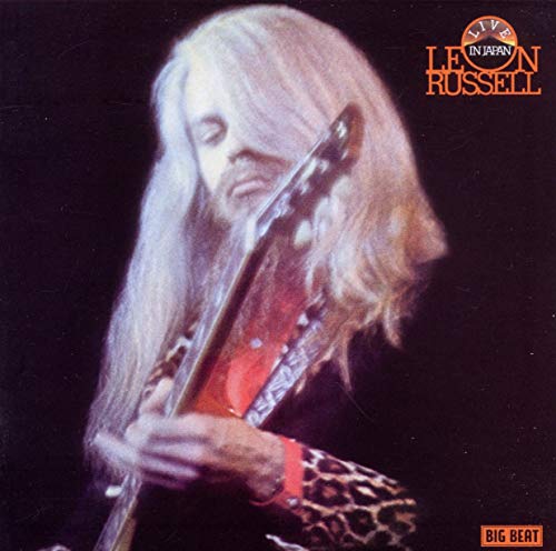 Leon Russell with long hair playing guitar on the Live In Japan album cover.