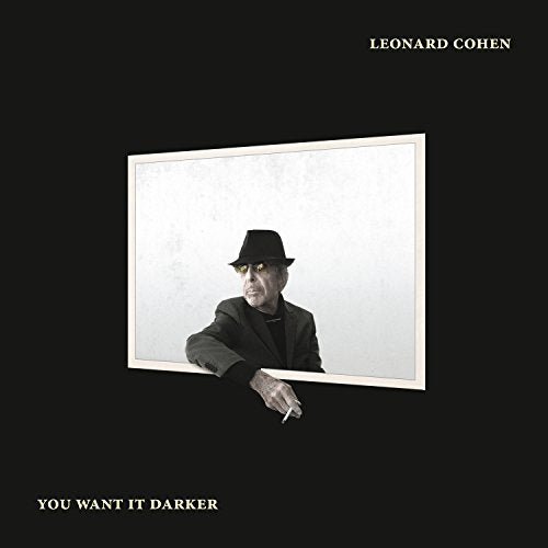 Leonard Cohen in a fedora and suit leaning out of a white rectangular frame.