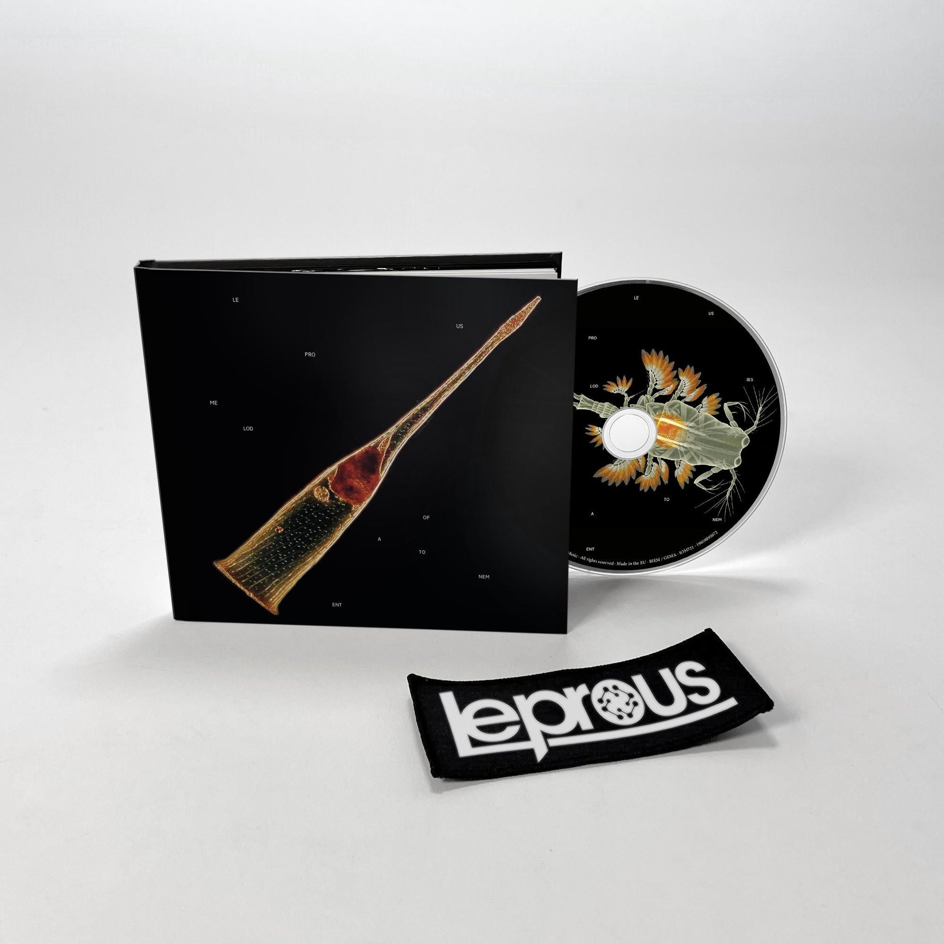 Leprous CD case with insect imagery, a wristband, and white background.