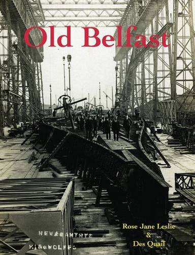 Black and white photo of men standing in a shipyard with large metal structures.