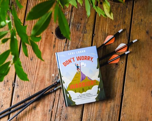 Book cover with mountain illustration and arrows on wooden surface.