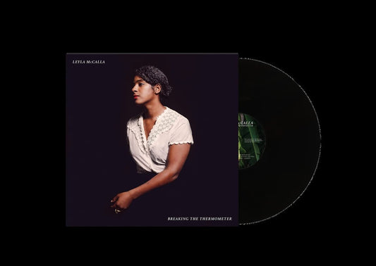 Vinyl record with album cover featuring a woman in white against a dark background.