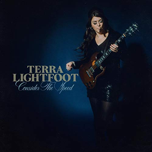 Woman in black holding a brown guitar, with album title and artist name.