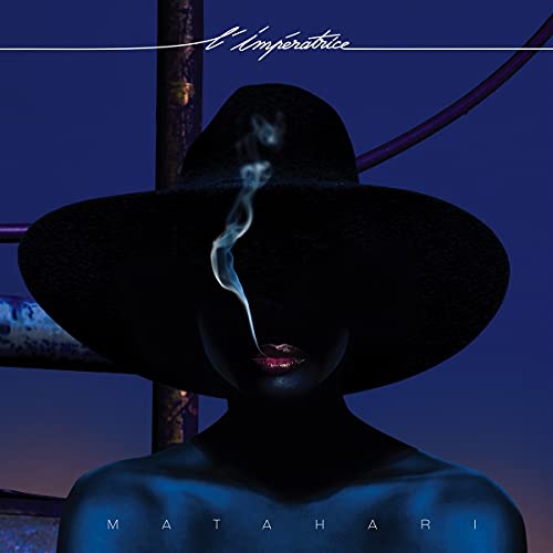 A person in a wide-brimmed hat exhales smoke against a dark blue background.