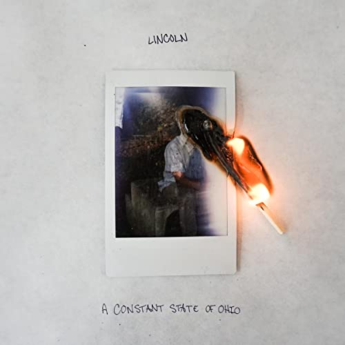 Vinyl album cover: Polaroid photo with a burning match overlay.