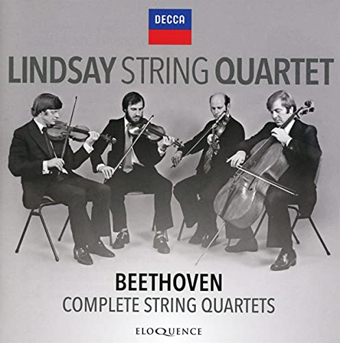 Black and white photo of four musicians playing string instruments.