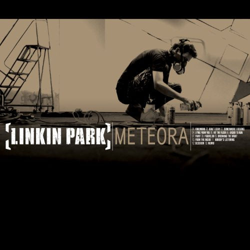 A person spray-painting in a studio with Linkin Park Meteora album text below.