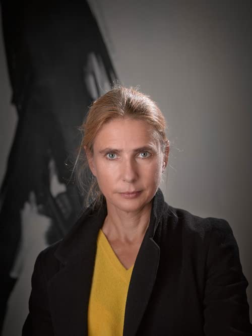 Portrait of a woman with blonde hair, wearing a black blazer.
