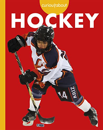 A hockey player in uniform holding a stick with a puck on red background.
