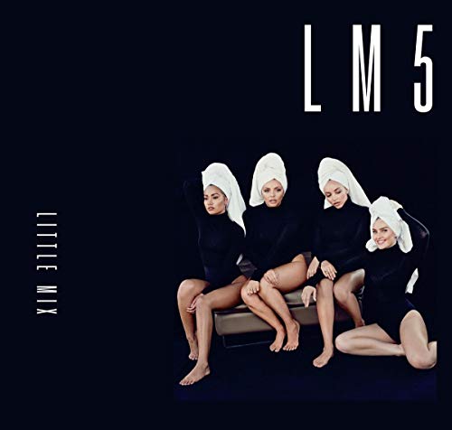 Four women in black bodysuits and white head towels sit together against black background.