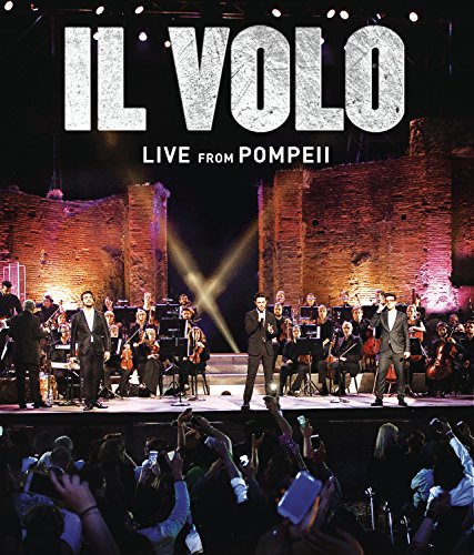 Il Volo performing with an orchestra on a stage at Pompeii.