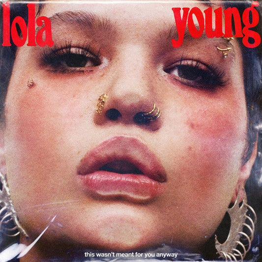 Close-up portrait of Lola Young with facial piercings and large earrings on CD cover.