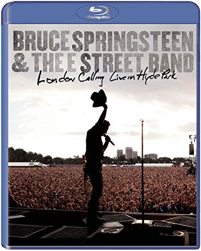 Bruce Springsteen silhouette performing on stage before a large crowd at Hyde Park.
