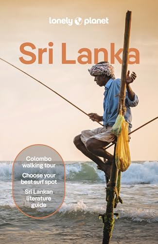 A stilt fisherman sits on a pole above the ocean waves at sunset.