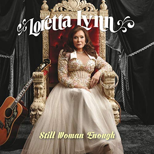 Loretta Lynn seated on an ornate throne with a guitar nearby.