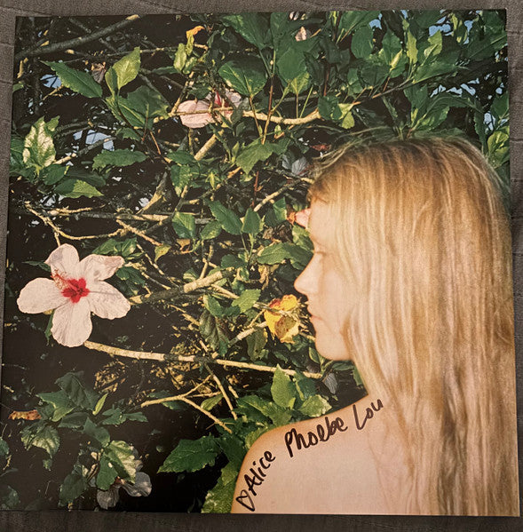 Vinyl album cover featuring a woman’s profile amidst green foliage.
