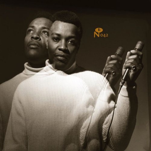 Black and white portrait of Lou Ragland singing into a microphone.