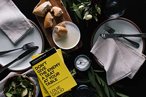 A yellow book titled Don't Give the Enemy a Seat at Your Table on a table.