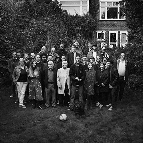 Black and white group portrait of people in a garden setting.