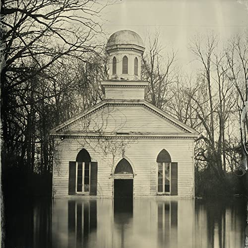 Old, weathered church building partially submerged in dark water.