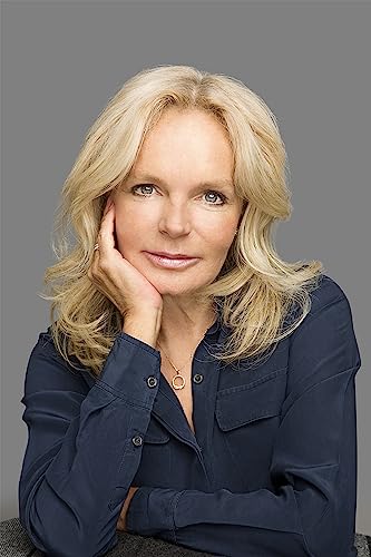 Blonde woman with fair skin, wearing a dark blue shirt, poses thoughtfully.