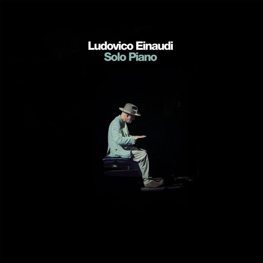 Ludovico Einaudi album cover: man playing piano in darkness.