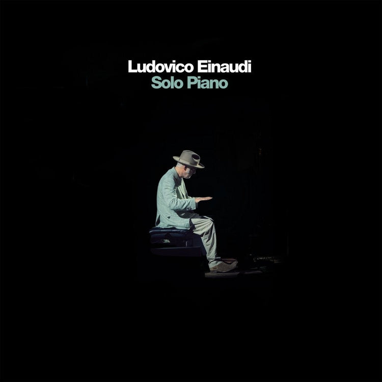 Ludovico Einaudi album cover: a man sits at a piano in shadow.