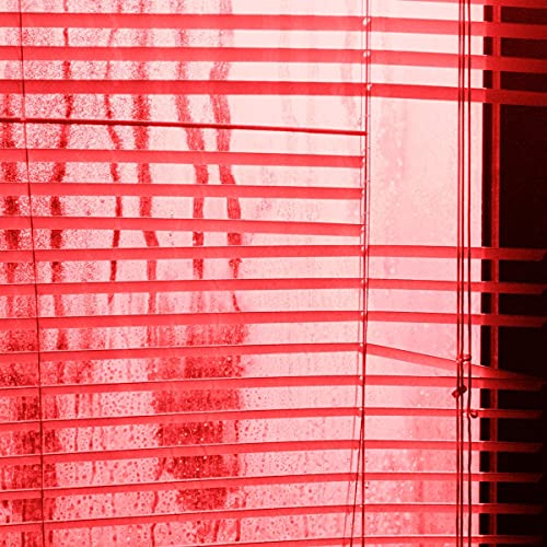 Red blinds covering a window with a brick wall outside.