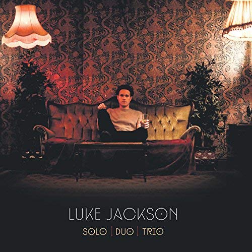 Album cover for Luke Jackson’s “Solo : Duo : Trio” featuring a man on a couch.