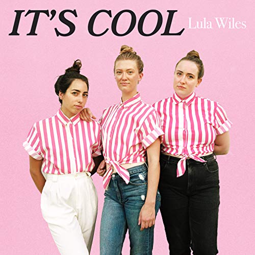 Three women in pink striped shirts stand together against a pink background.