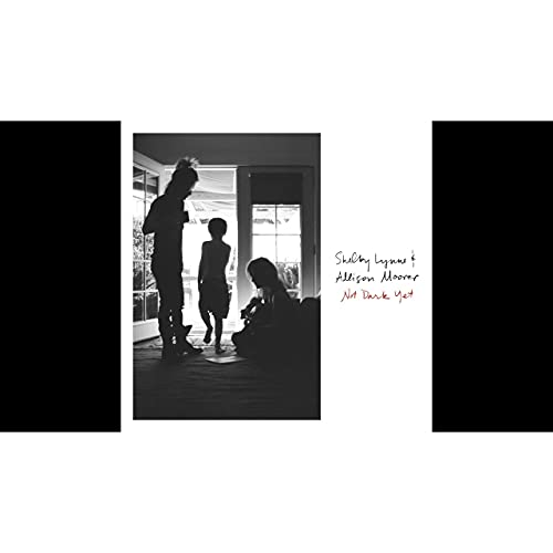 Black and white photo of silhouettes in a doorway with handwritten text to the right.