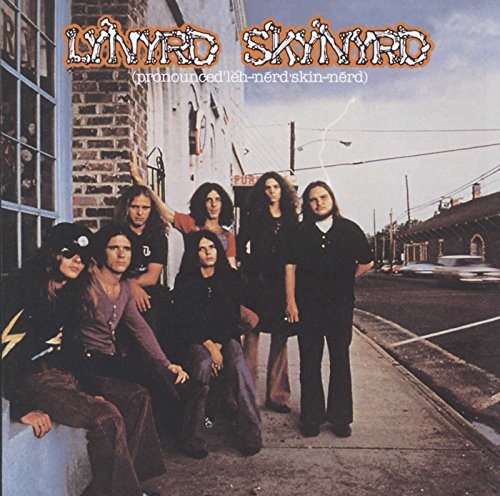Lynyrd Skynyrd band portrait in front of a brick building.