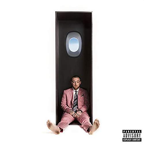 Mac Miller sits in a narrow, dark space with a window above.