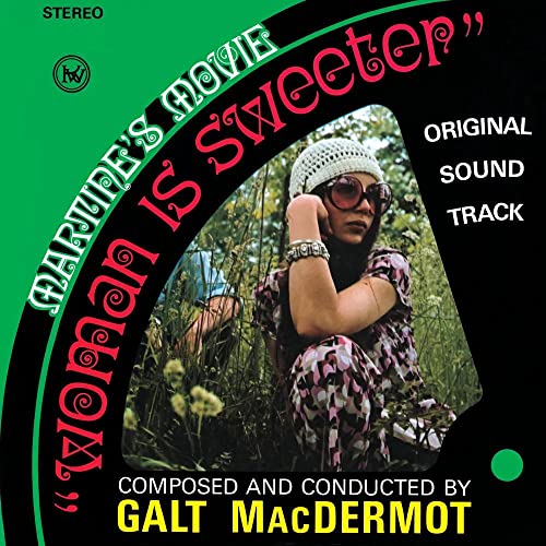 Woman in a crochet hat and sunglasses sits in tall grass on album cover.