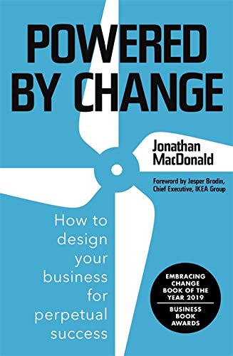 Book cover with bold white text "Powered By Change" and a wind turbine graphic.