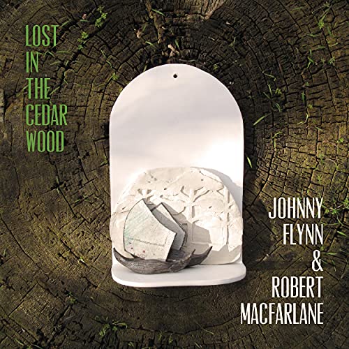 Album cover: white sculpture on wood, text “Lost In The Cedar Wood”.
