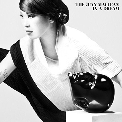 Black and white album cover with woman holding a helmet, artist name and title.