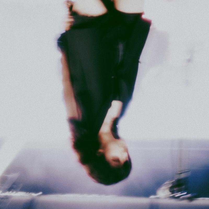 Blurred image of a person in a dark dress, upside down.