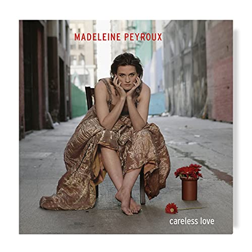 Madeleine Peyroux album cover, seated woman in a dress, red flowers.