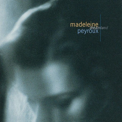 "Vinyl record cover with dark, blurry image and 'madeleine peyroux dreamland' text in yellow and blue."