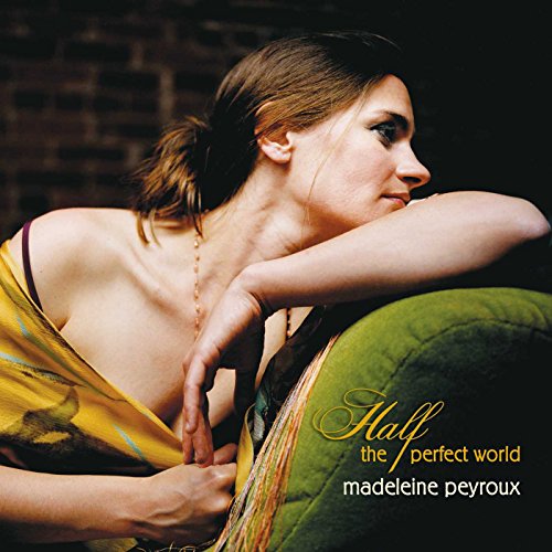 Madeleine Peyroux leaning on a green sofa, album cover for Half the Perfect World.