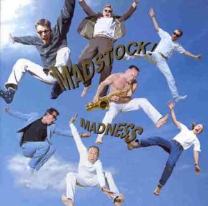 Band members of Madness jumping in the air against a blue sky.